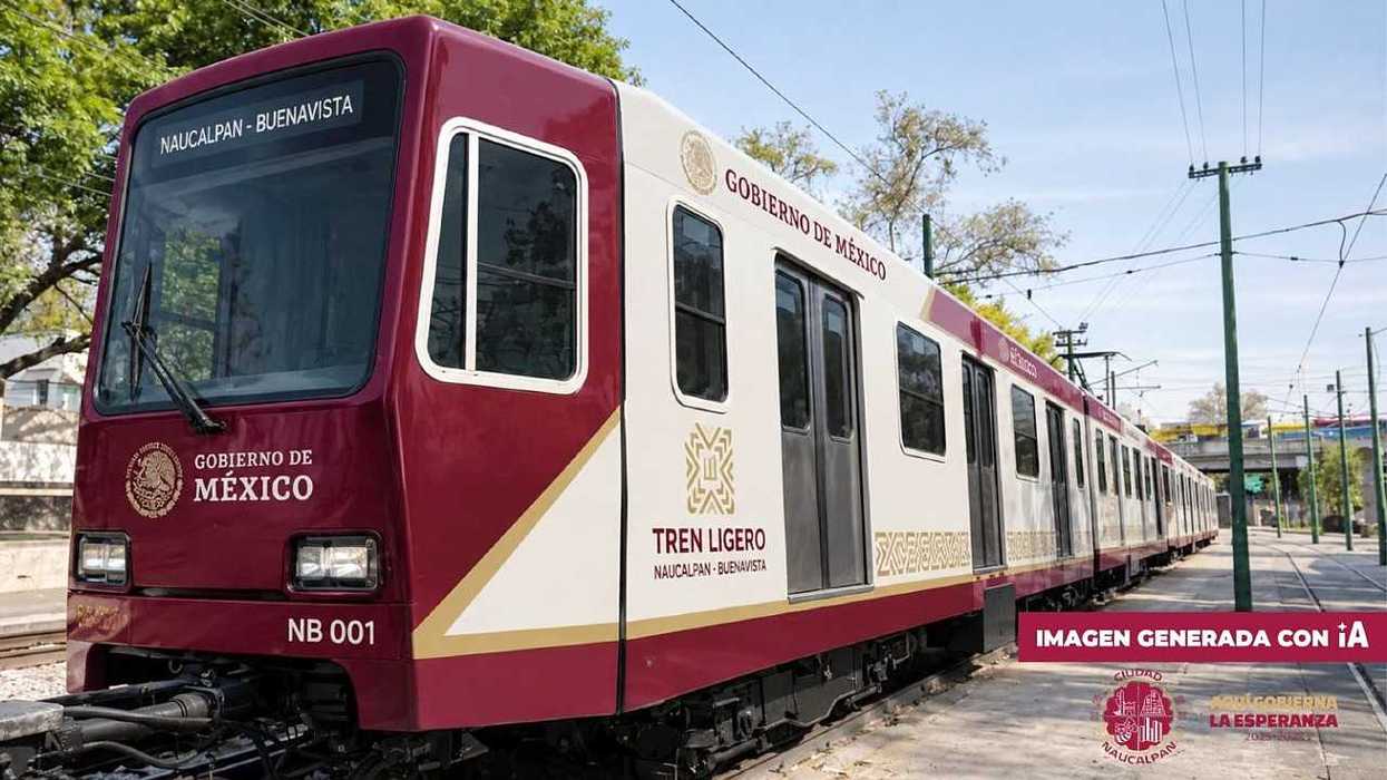 A maroon-and-white Mexican light rail train sits on the tracks beneath overhead power lines.