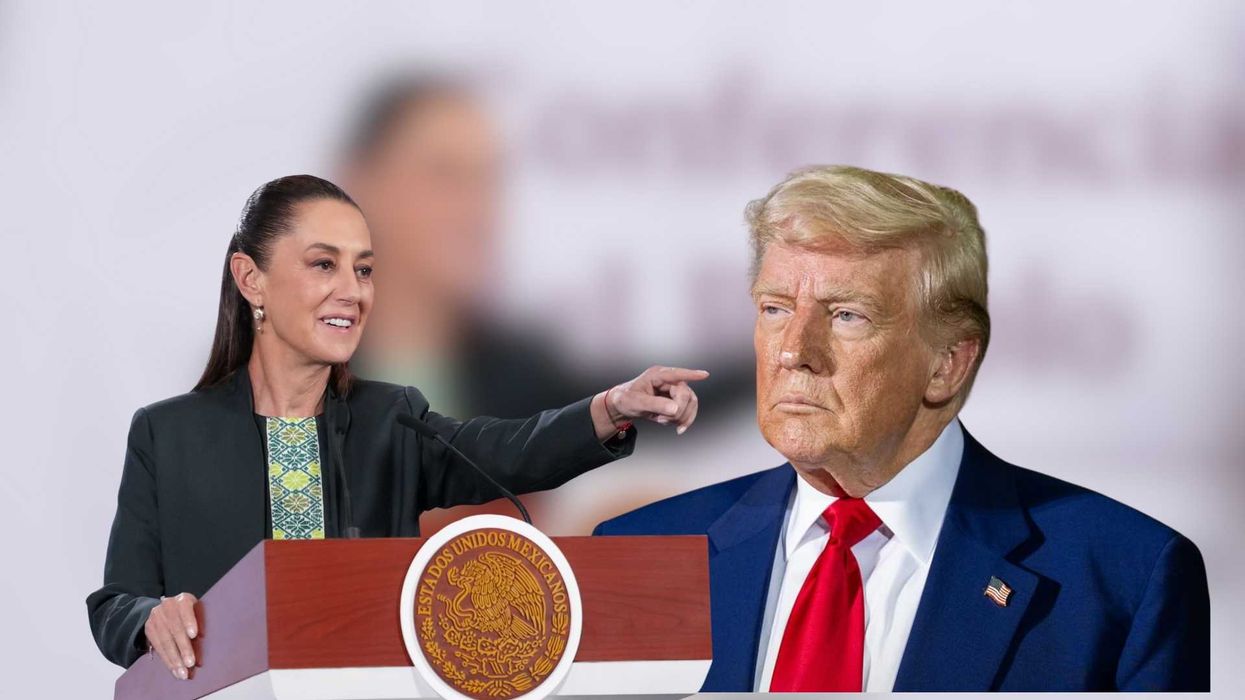 A woman at a podium points beside a large cutout of a man in a suit.