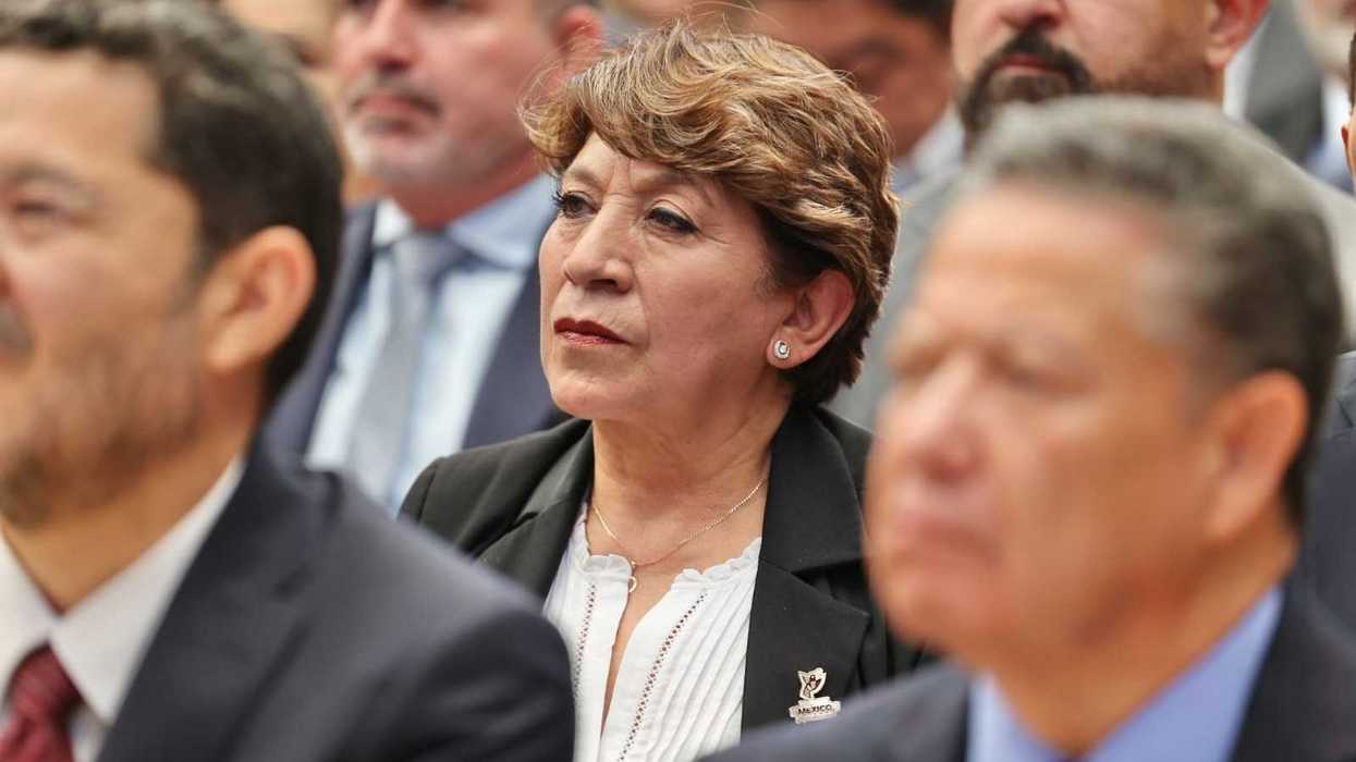 A woman in focus among people at a formal event.