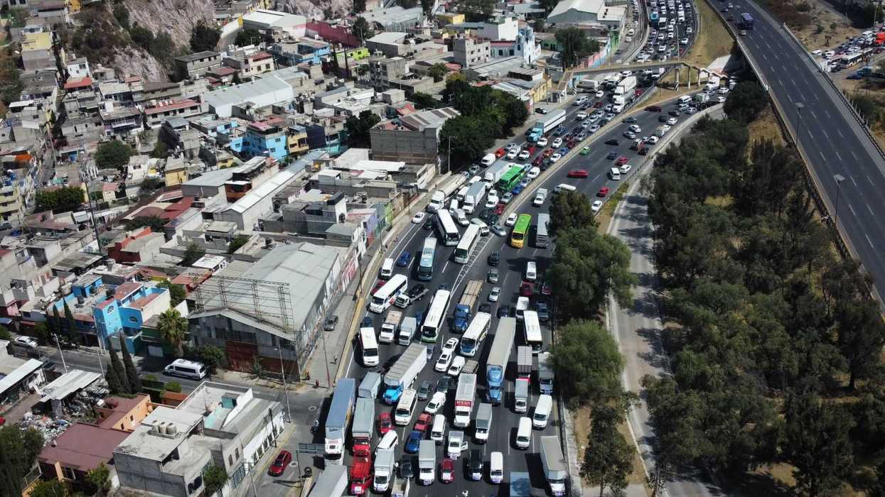 Aerial view of heavy traffic congestion on a highway next to a residential area.