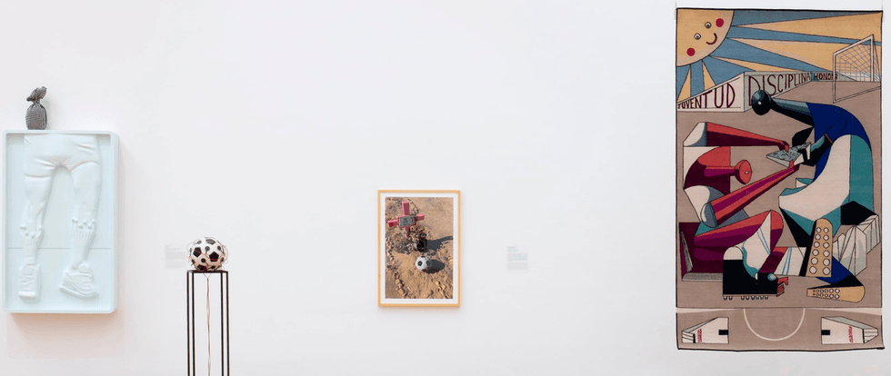 Art gallery wall with a sculpture, photo, and abstract painting featuring soccer themes.