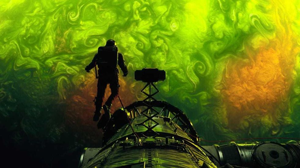 Astronaut floats near a spacecraft against a vivid, swirling green and orange background.