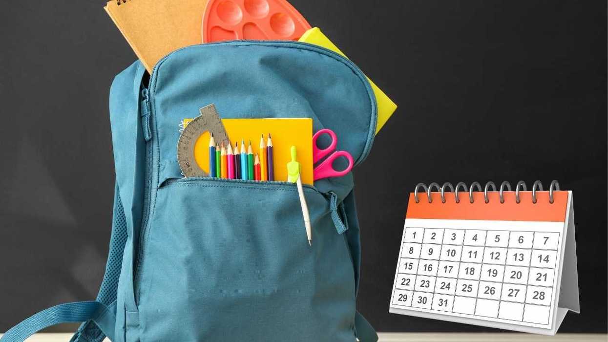 Blue backpack with school supplies and a calendar nearby.