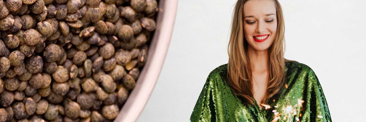 Bowl of lentils beside a smiling woman in a green sequin dress with a sparkler.