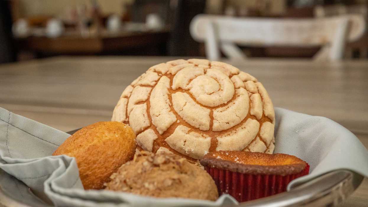 Canasta con concha y diferentes variedades de pan dulce mexicano servidas en una mesa.