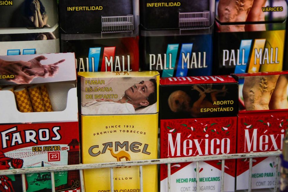 Cigarette packs with health warnings in Spanish on display.
