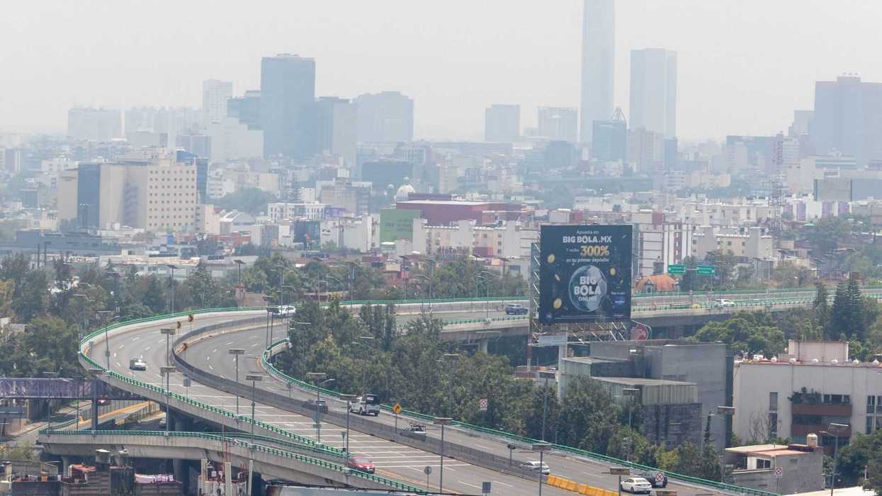 Cityscape with highways and skyscrapers under a hazy sky.