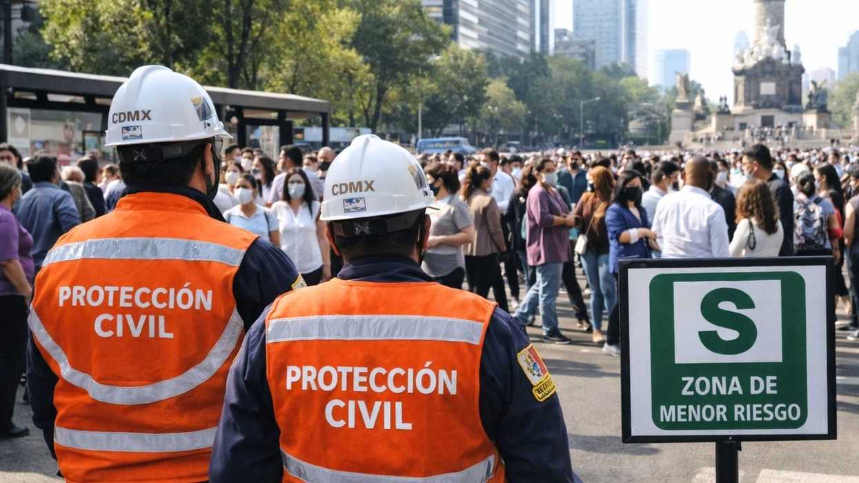 Civil protection workers oversee a crowd in a designated safety zone on a city street.