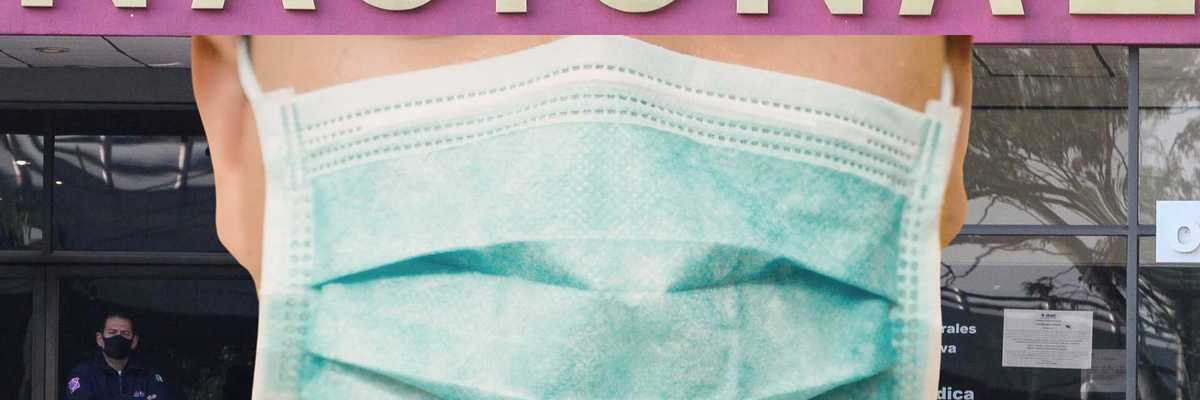 Close-up of a person wearing a green mask in front of a "NACIONAL" sign.