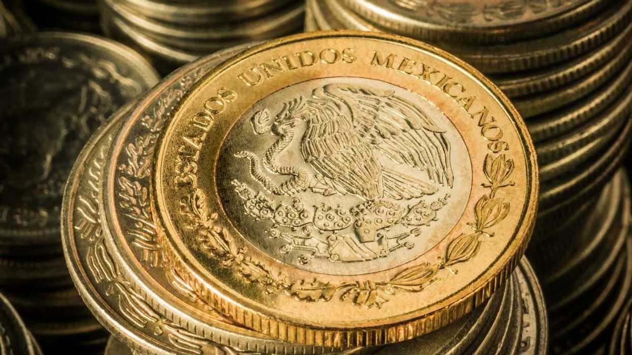 Close-up of stacked Mexican coins featuring an eagle and "Estados Unidos Mexicanos."