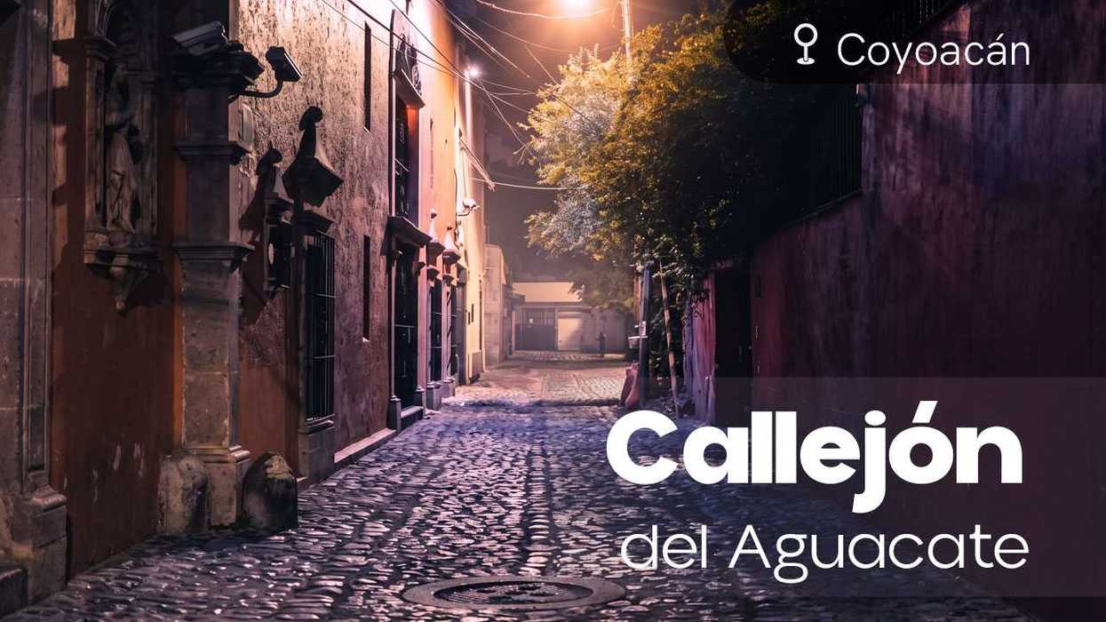 Cobblestone alley at night in Coyoacán, dimly lit by streetlights, titled "Callejón del Aguacate."