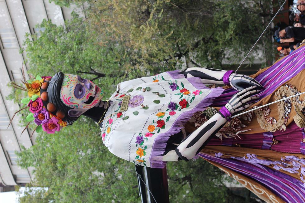 Colorful D\u00eda de los Muertos puppet with floral headdress and embroidered dress.