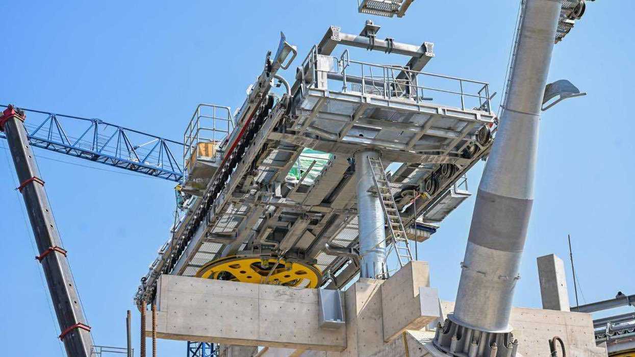 Construction of a cable car station with cranes and steel structures.
