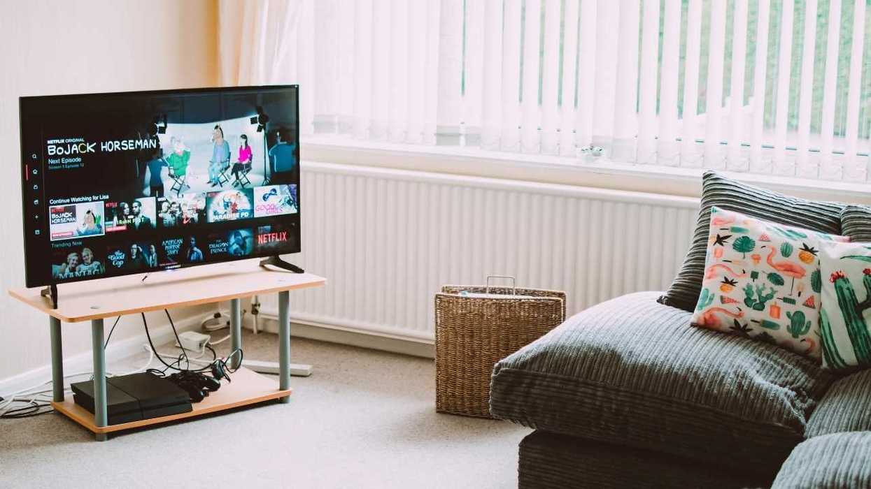 Cozy living room with TV on Netflix, gray sofa, and colorful cushions.