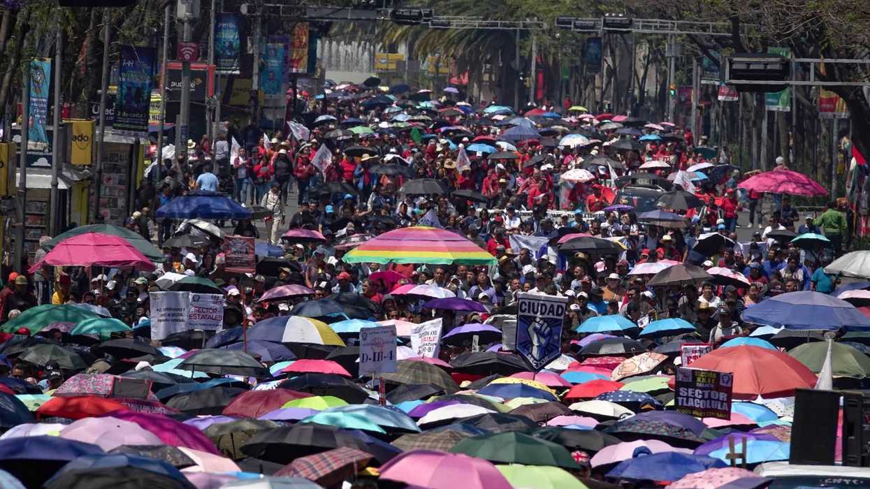 Crowd with colorful umbrellas during a street protest.