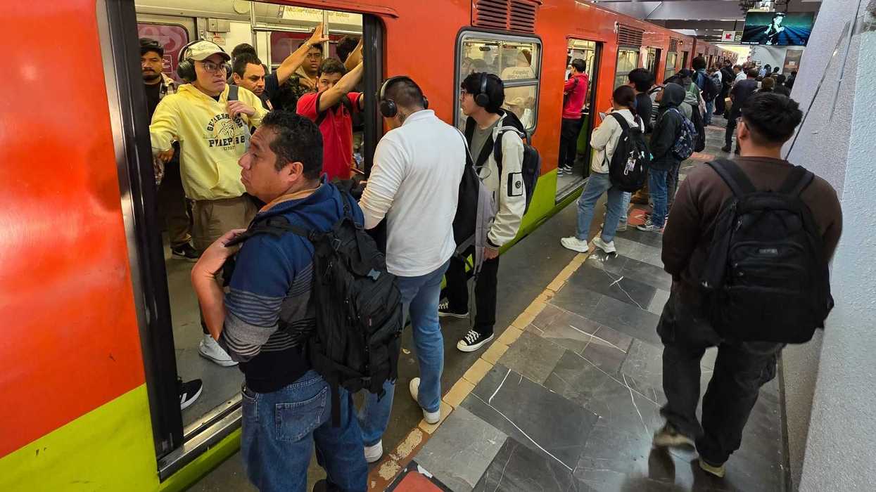 Crowded metro station with people boarding and waiting on the platform.