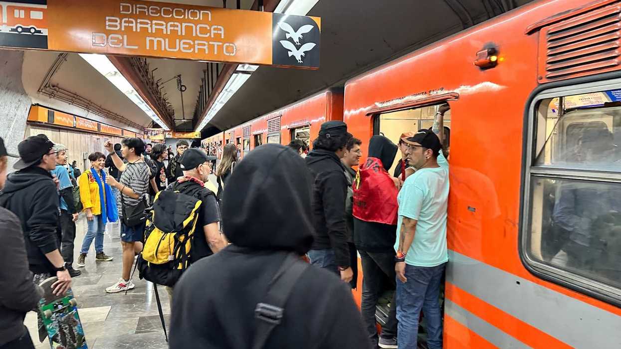 Crowded subway platform with an orange train, "Barranca del Muerto" sign above.