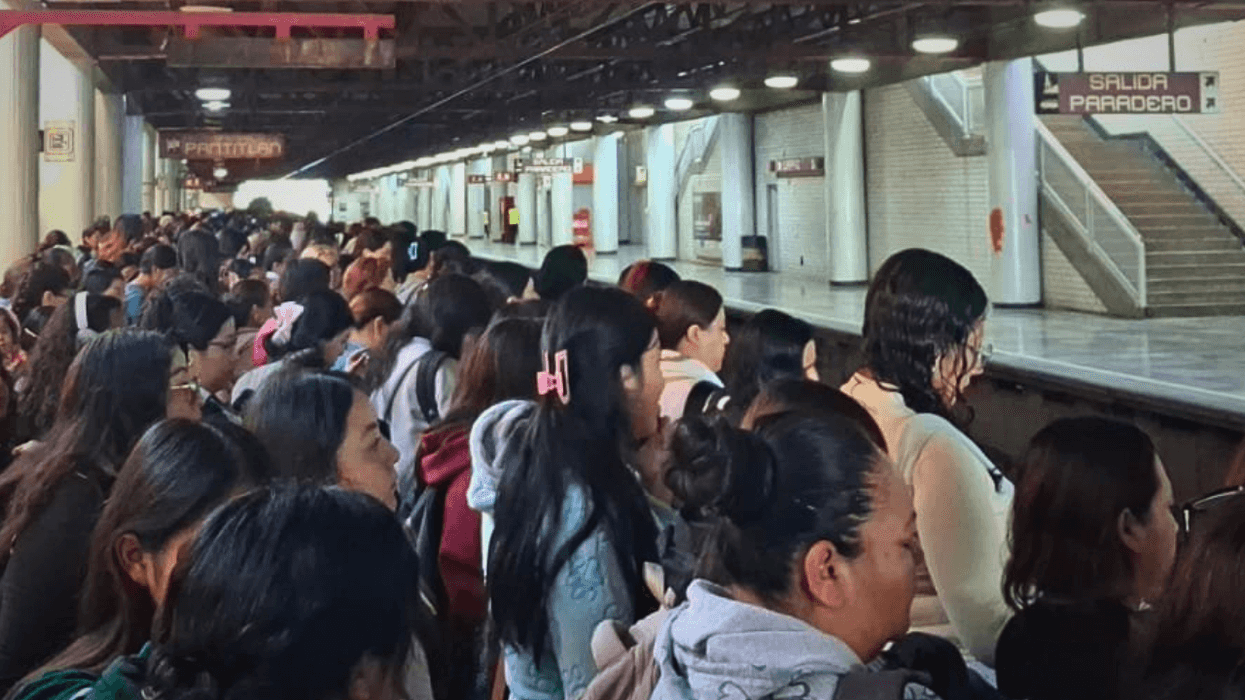 Crowded subway platform with many people waiting for a train.