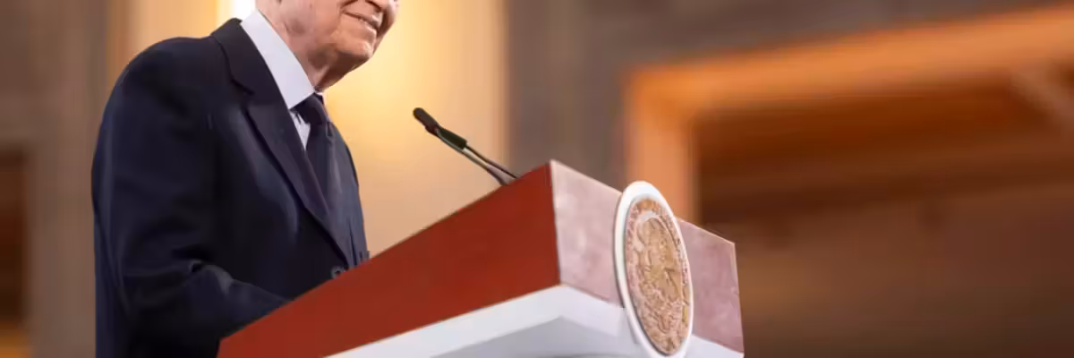 Elderly man speaking at a podium with an emblem, in a formal setting.