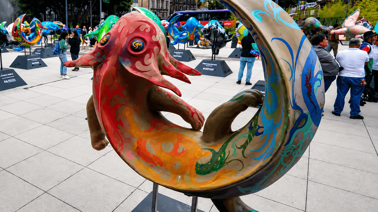 Escultura de ajolote gigante intervenida con colores y diseños artísticos en una exposición al aire libre en la CDMX