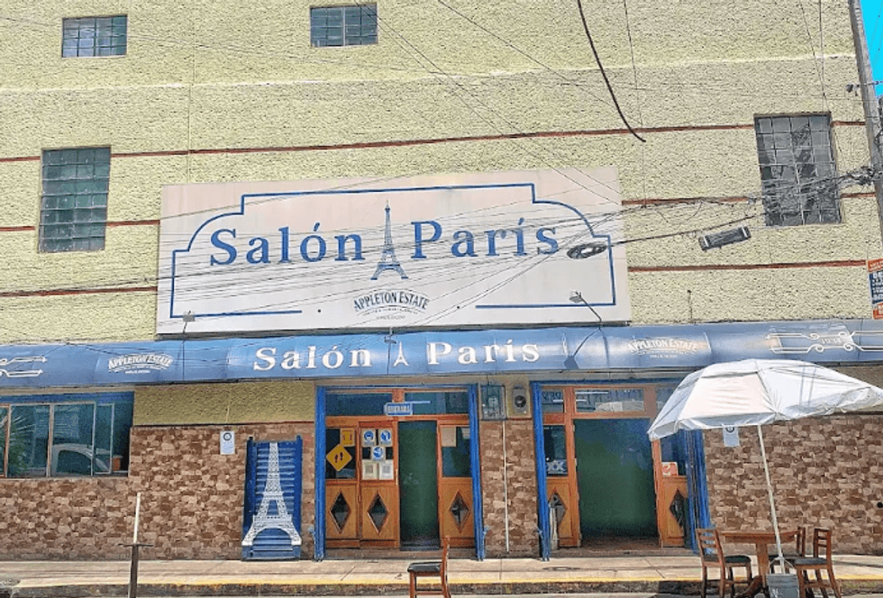 Exterior of "Sal\u00f3n Paris" with a large sign and patio seating.