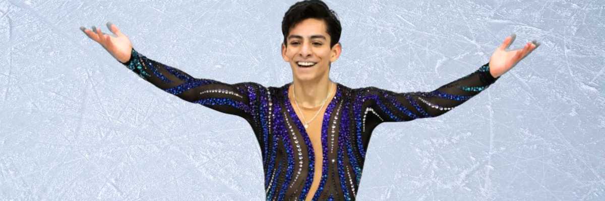 Figure skater in a sequined outfit performs on ice with arms outstretched.