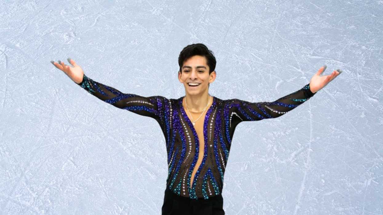 Figure skater in a sequined outfit performs on ice with arms outstretched.