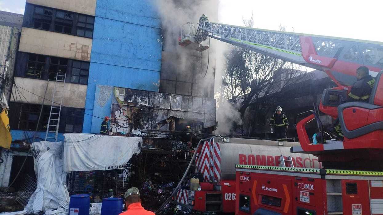 Firefighters extinguish a building fire with ladder truck assistance.