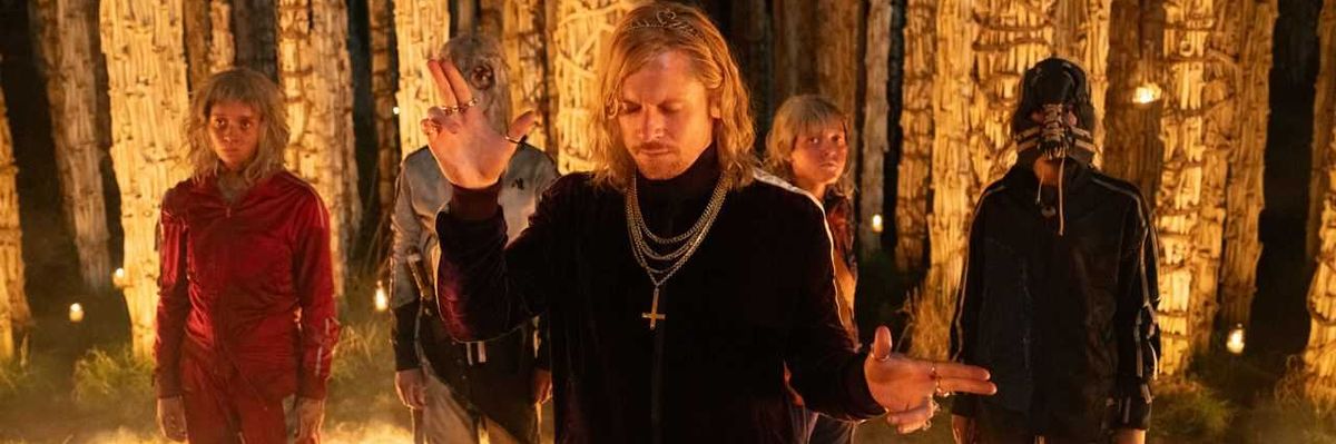 Five mysterious figures stand surrounded by glowing pillars at night.