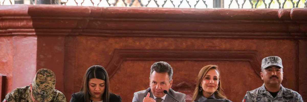 Five people seated at a table during a formal event.
