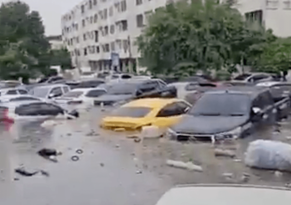 Flooded parking lot with partially submerged cars.