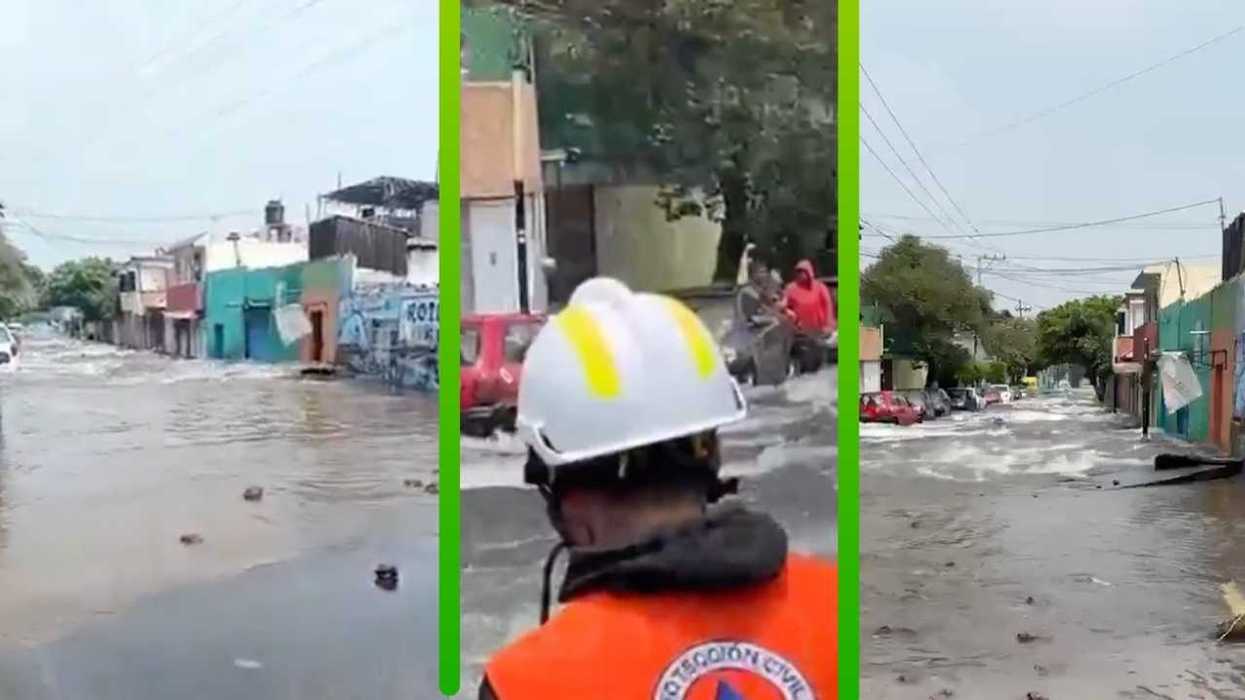 Flooded street with rescue worker in orange vest and helmet, people on a vehicle.