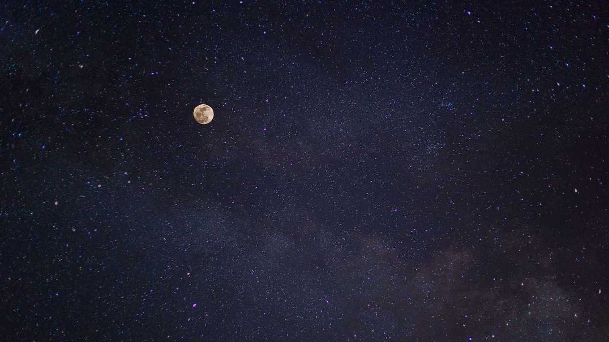 Full moon and starry night sky with a faint Milky Way.