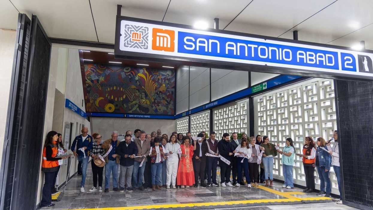 Group at San Antonio Abad metro station entrance during ribbon-cutting ceremony.