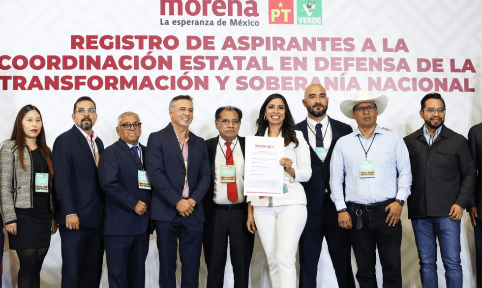 Group of people at a political event with a woman holding a certificate.