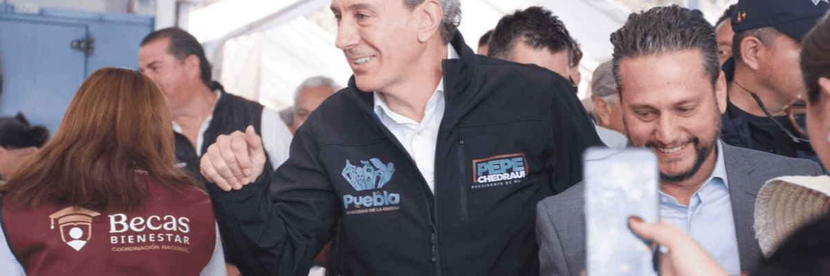 Group of people smiling and interacting at an outdoor event.