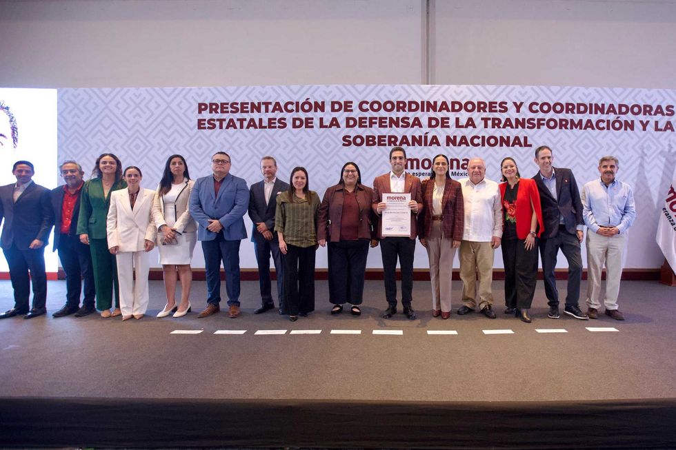 Group of people standing on stage at a "Morena" political event.