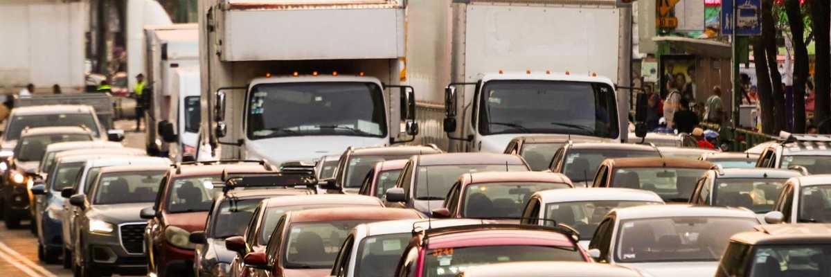 Heavy city traffic with cars and trucks on a congested road.