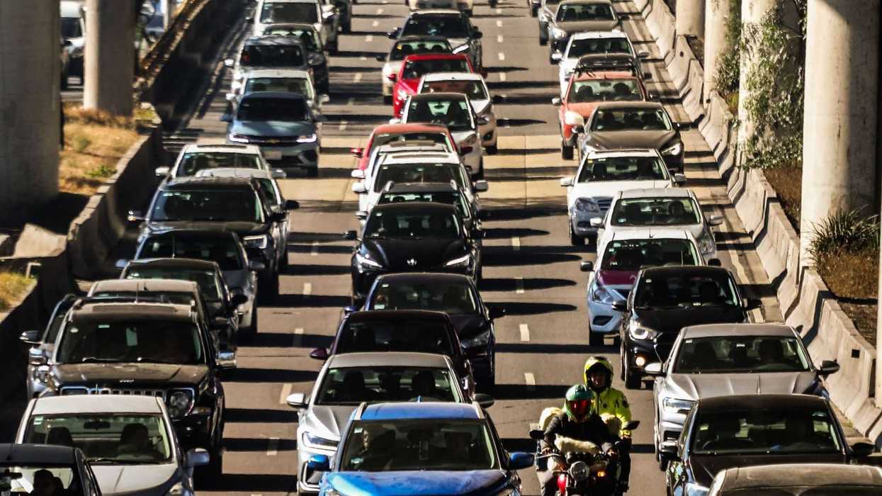Heavy traffic with cars and a motorcycle on a multi-lane highway.