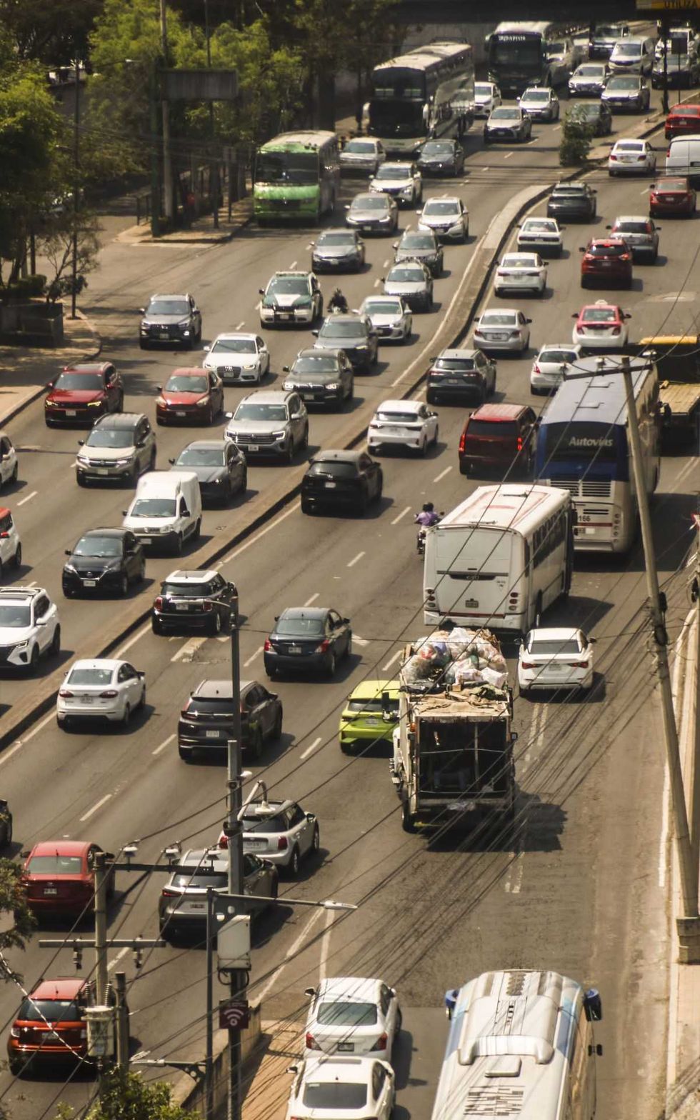 Heavy traffic with cars, buses, and trucks on a multi-lane city road.