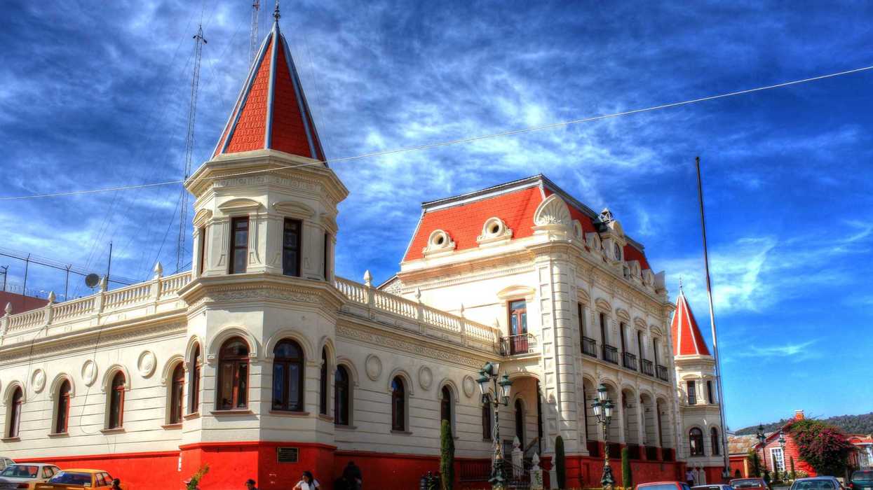 Historic building with red roofs under a vibrant blue sky.