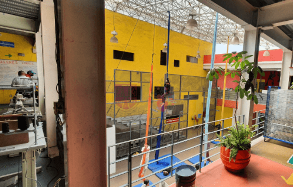 Indoor space with colorful walls, machinery, and potted plants on a ledge.