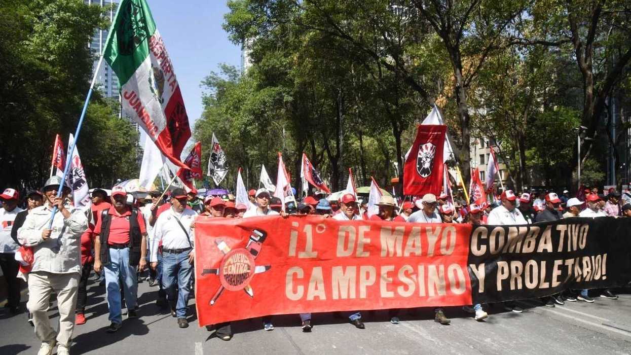 Labor Day march with banners and flags, featuring "1° de Mayo Combativo y Proletario" text.