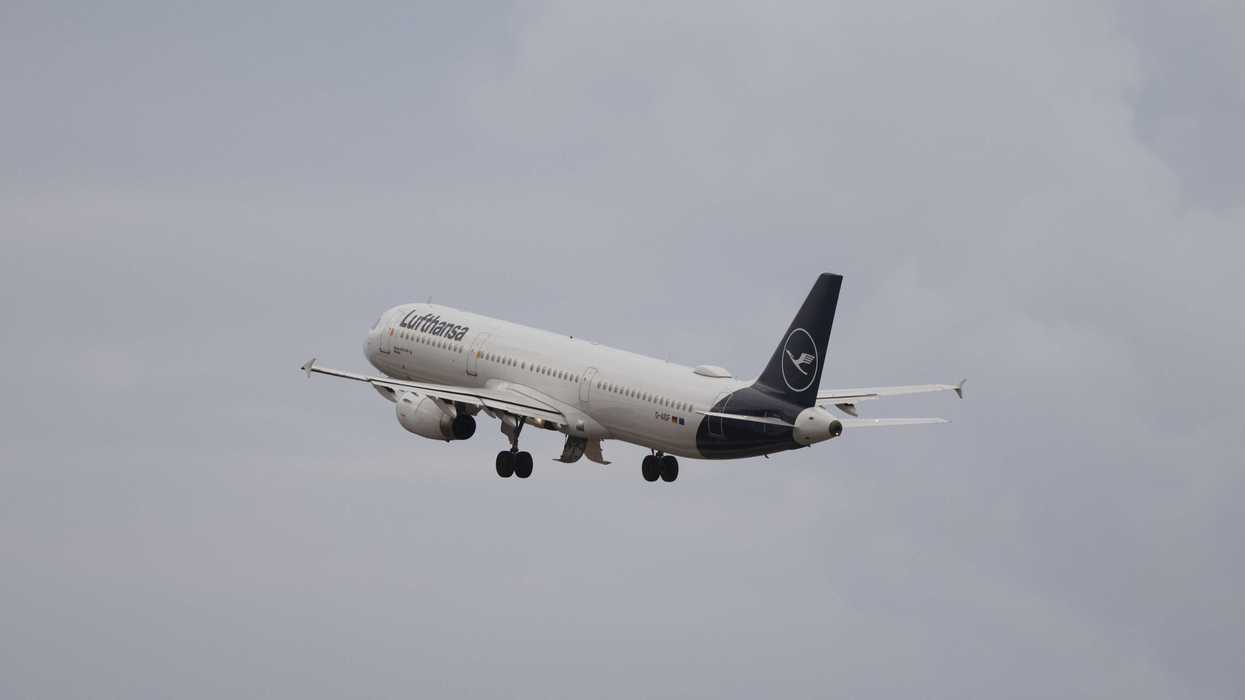 Lufthansa airplane ascending into cloudy sky.
