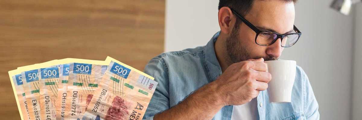 Man drinking coffee, holding Mexican 500 peso bills.