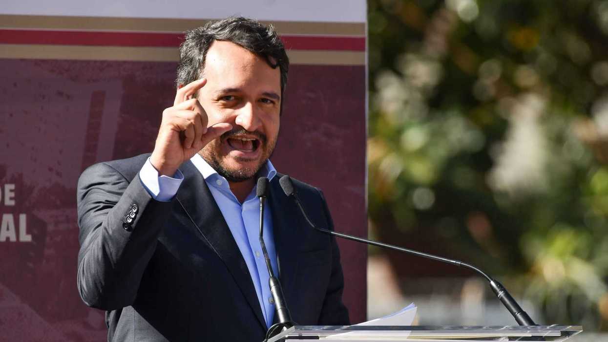 Man in a suit speaking passionately at a podium with "morena" logo.