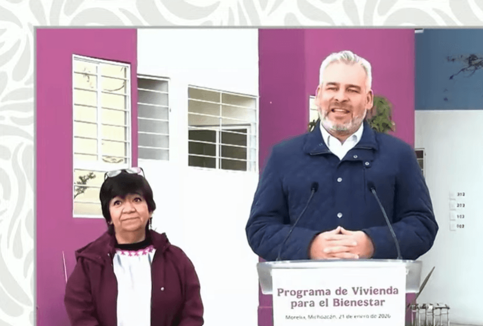 Man speaking at a podium with a woman beside him, "Programa de Vivienda para el Bienestar."