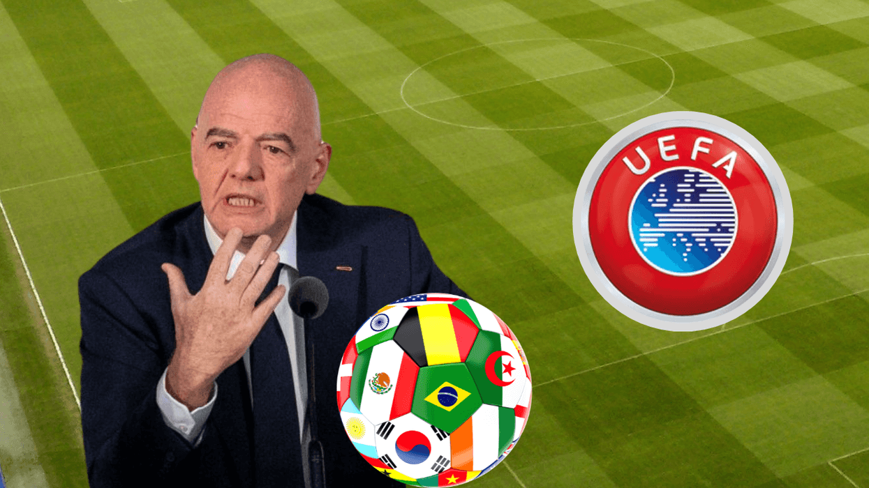Man speaking near UEFA logo and a soccer ball with flags on a field.
