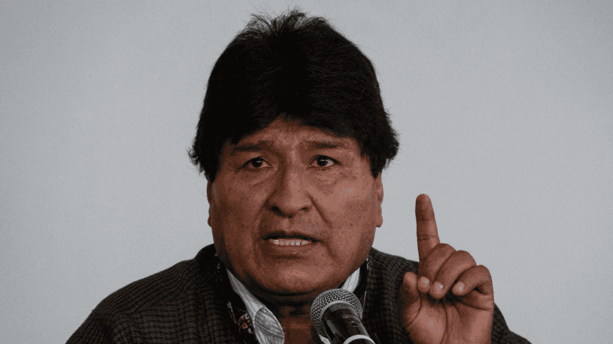Man speaking passionately with a raised finger at a microphone.