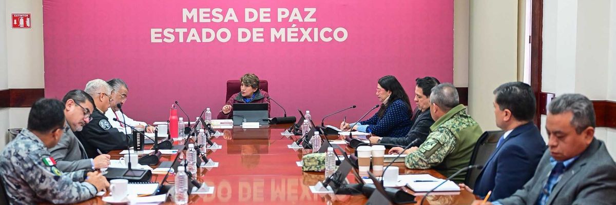 Meeting participants at a long table under a "Mesa de Paz Estado de México" sign.